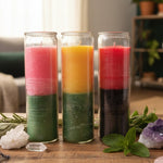 Three multicolored candles in glass jars with a dark background