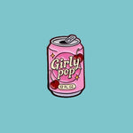 Enamel pin of a pink 'Girly Pop' can held between fingers against a pink background