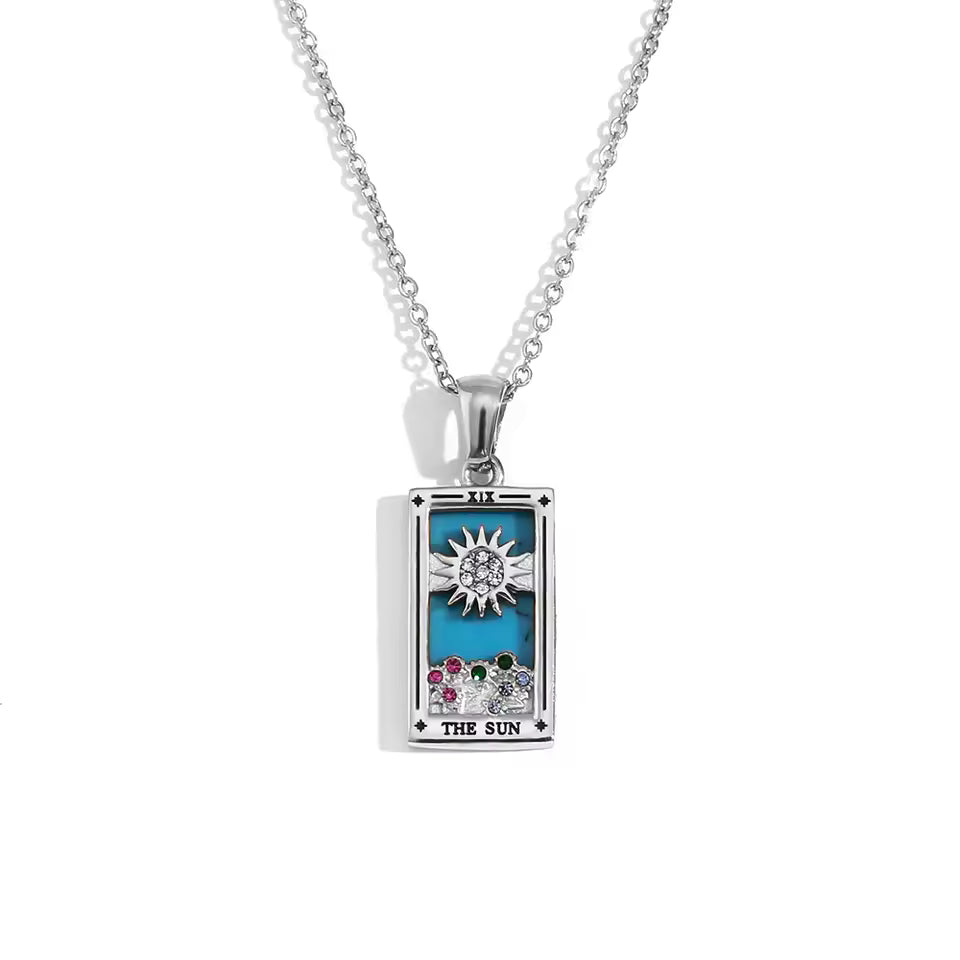 Silver pendant with 'The Sun' design on a white background