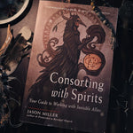 Book titled 'Consorting with Spirits' on a dark background with mystical elements.