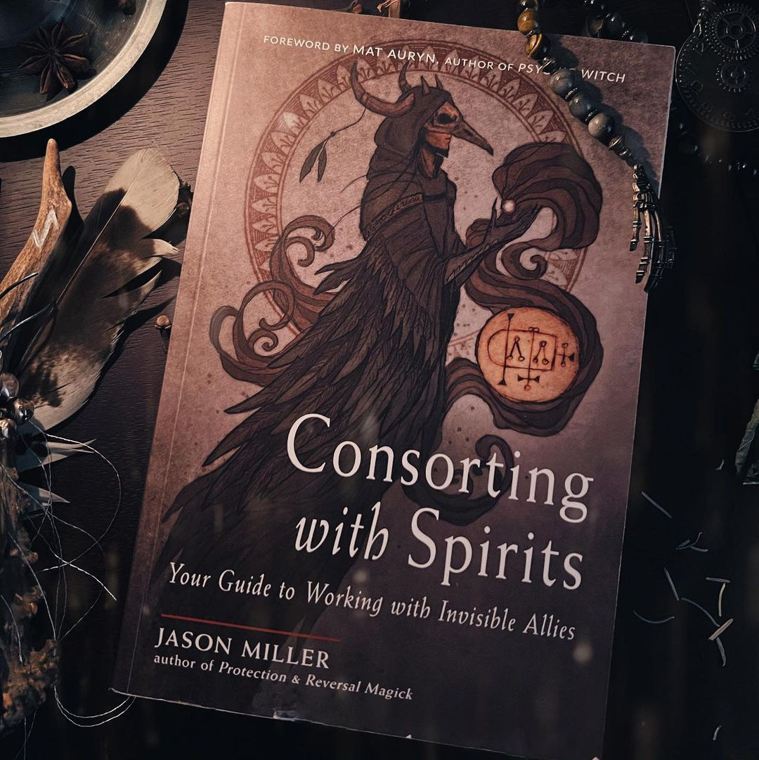 Book titled 'Consorting with Spirits' on a dark background with mystical elements.