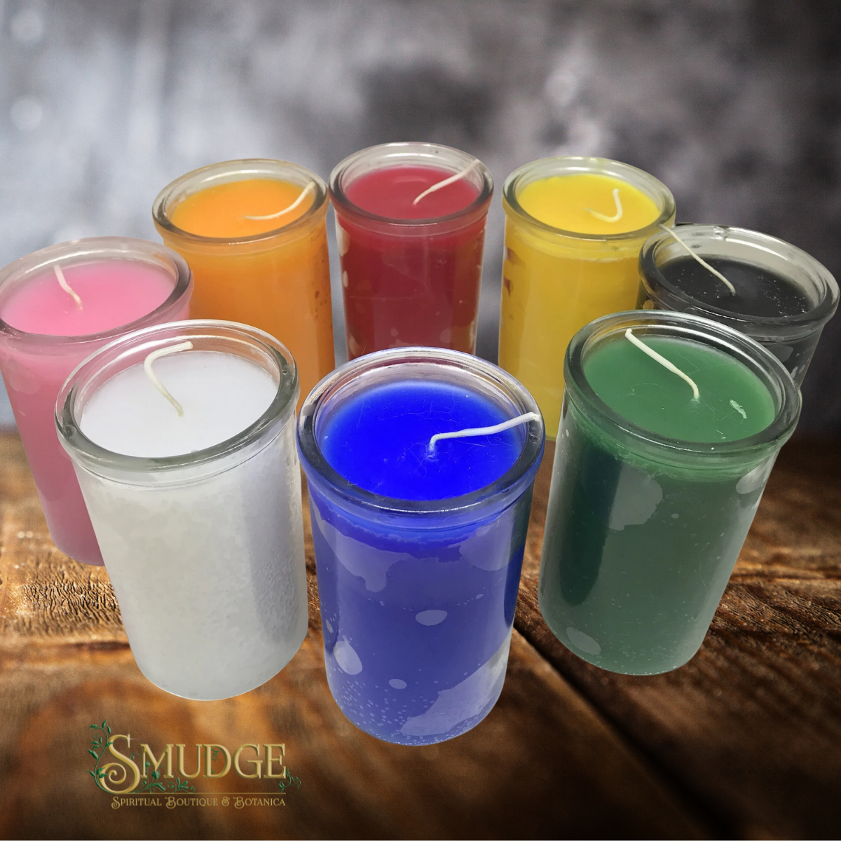 Set of colorful candles in glass containers on a wooden surface with 'Smudge' branding.