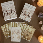 White Light Oracle cards and guidebook on a wooden surface
