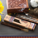 Incense sticks with packaging and a wooden incense box on a textured surface.