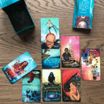 the light seer's tarot deck with the cards laid out on a wooden table.