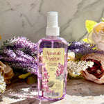 Bottle of 'Agua de Violetas' with floral decorations on a marble surface