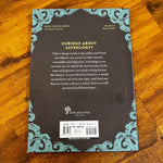 Back cover of a book on astrology with decorative elements on a wooden surface