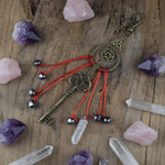 Decorative keychain with a key, beads, and a crystal on a wooden surface