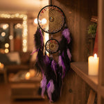 Decorative fan with purple and black feathers on a reflective surface