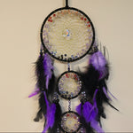 Decorative dreamcatcher with beads and feathers on a neutral background