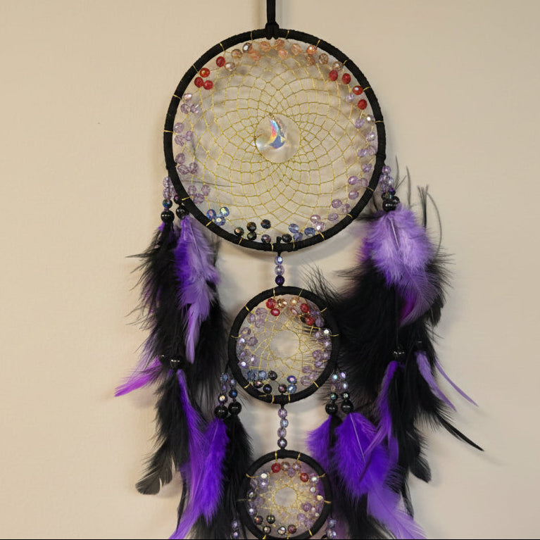 Decorative dreamcatcher with beads and feathers on a neutral background