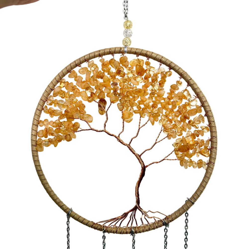 Decorative wall art with a tree design made of beads on a white background