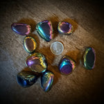 Iridescent stones on a wooden surface with a coin for scale