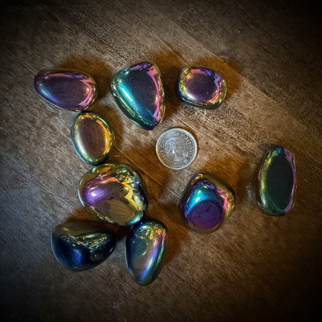 Iridescent stones on a wooden surface with a coin for scale