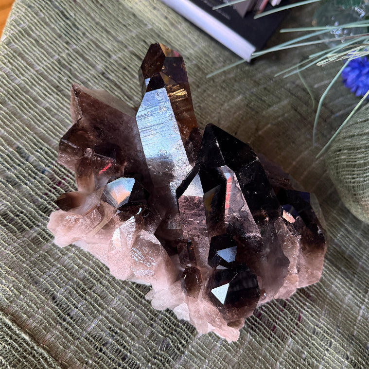 Crystal formation on a textured surface with a book and plants in the background