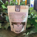 Tea package labeled 'Cold & Flu Health & Wellness Tea' on a textured surface with greenery in the background.