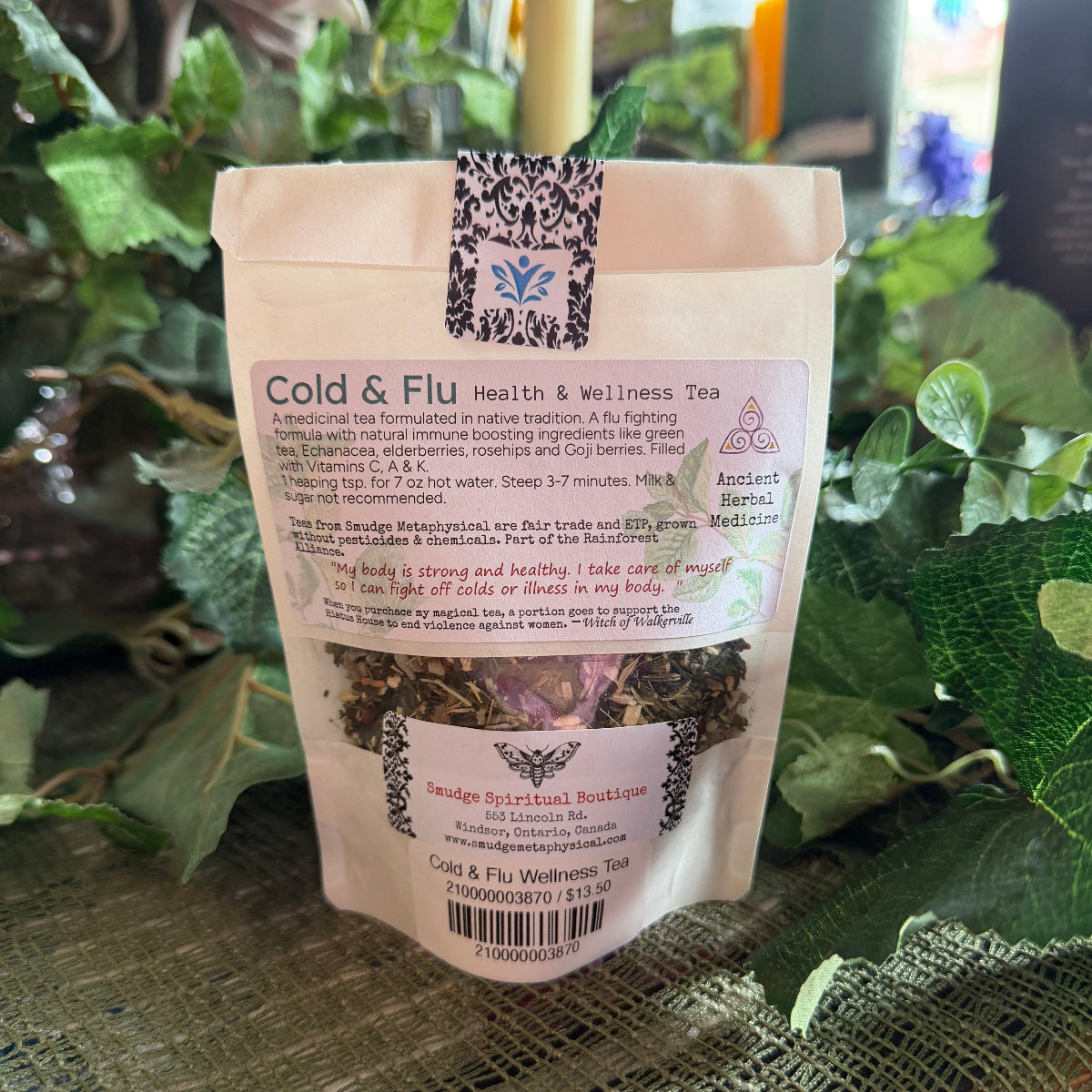 Tea package labeled 'Cold & Flu Health & Wellness Tea' on a textured surface with greenery in the background.