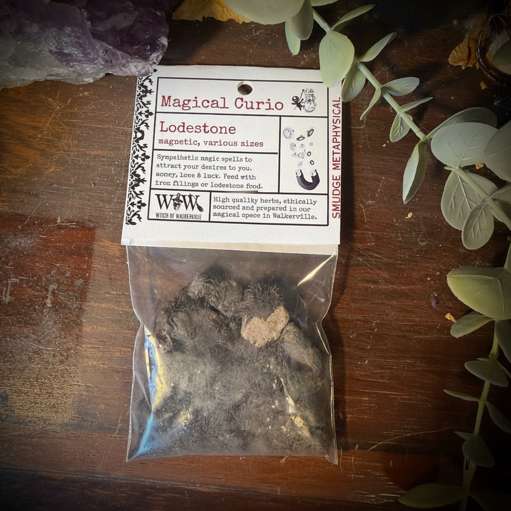 Bag of lodestones with a label on a wooden surface surrounded by plants