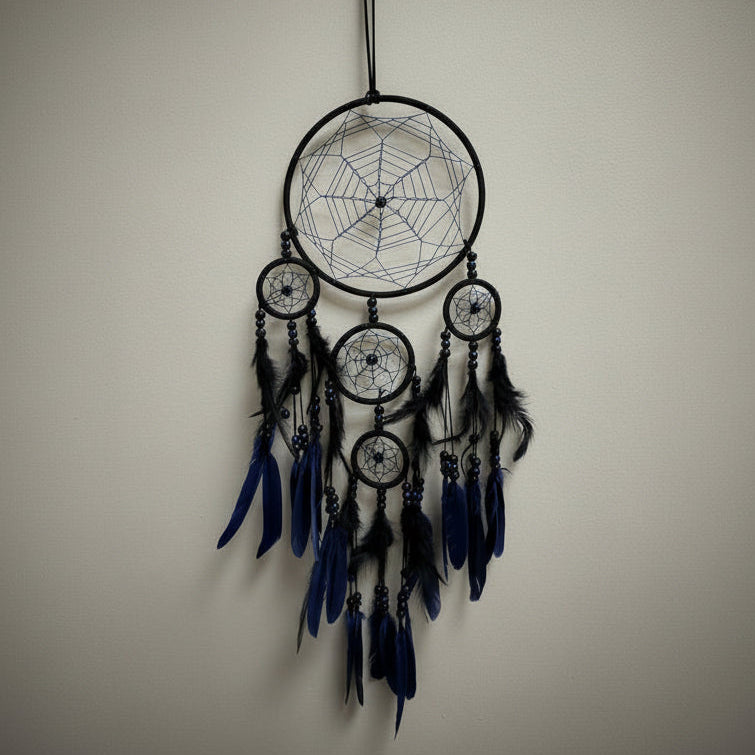Hand holding a dreamcatcher against a plain wall