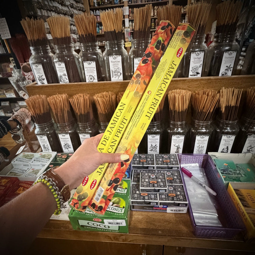 Hand holding a box of 'Jamaican Fruit' incense in a store with various incense products.