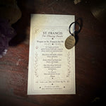 Card with text and a keychain on a wooden surface with crystals