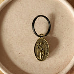 Keychain with a circular emblem on a textured surface