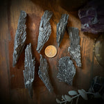 Mineral samples on a wooden surface with a candle and crystal in the background