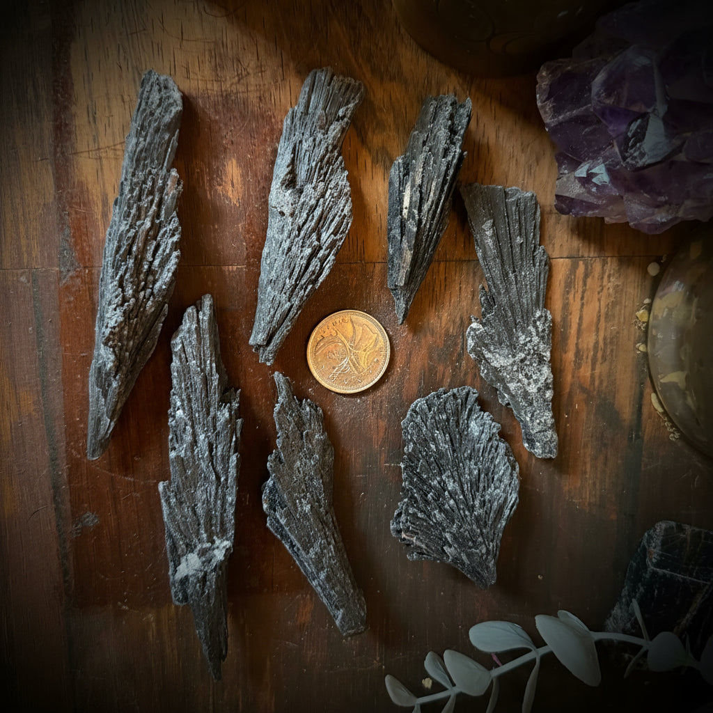Mineral samples on a wooden surface with a candle and crystal in the background