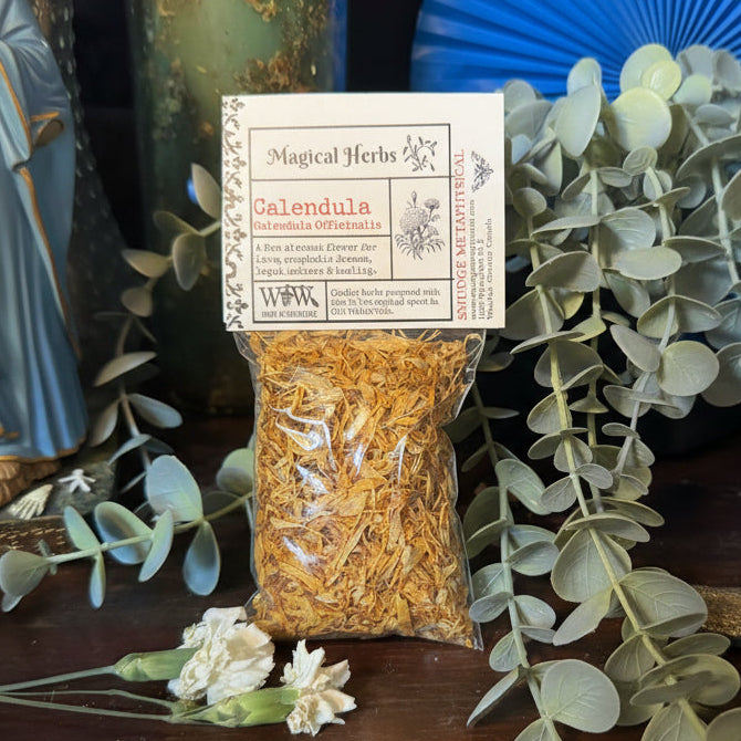 Bag of dried Calendula flowers with a label on a wooden surface with greenery.