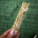 Mugwort smudge sage stick being held by a hand