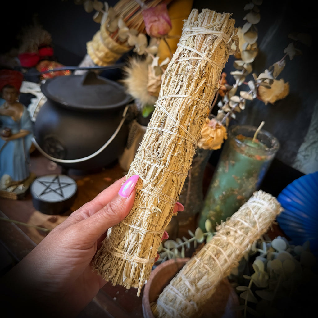 Hand holding a herbal bundle stick of mugwort.