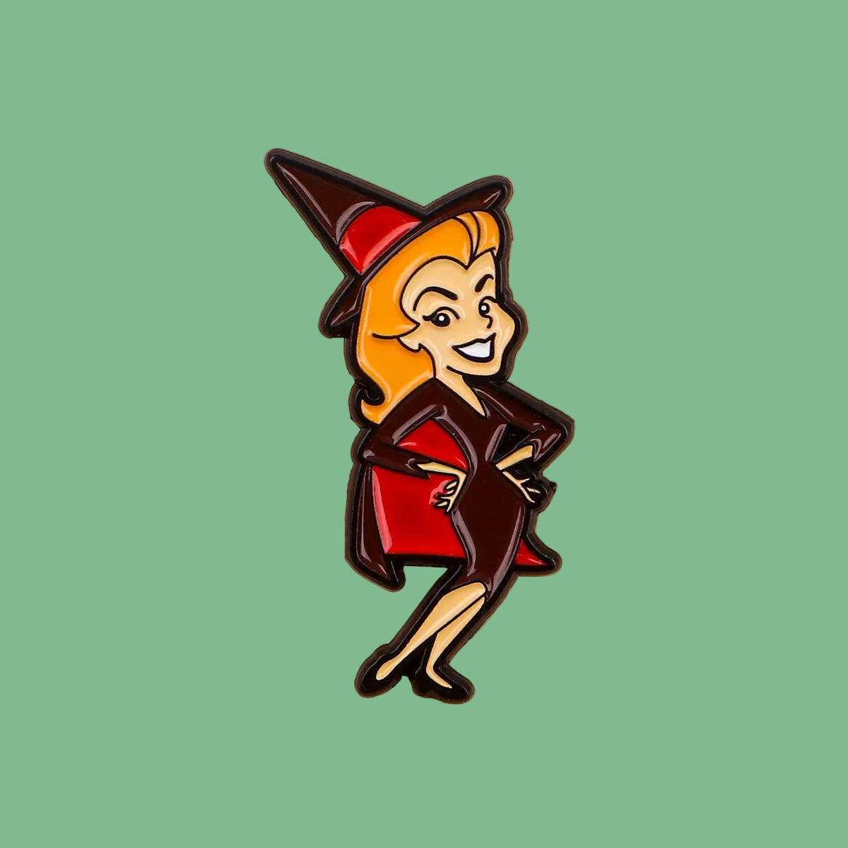 Witch-themed enamel pin on a wooden surface
