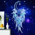 Decorative dreamcatcher with blue feathers against a starry night sky background