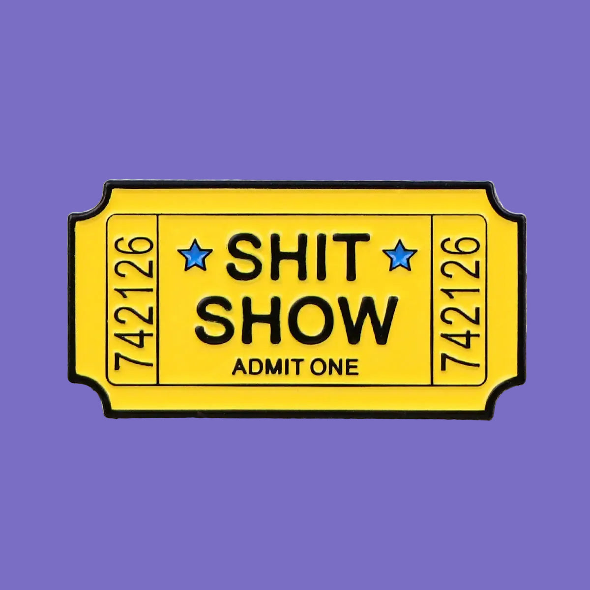 Ticket-shaped pin with 'SHIT SHOW' text on a denim background