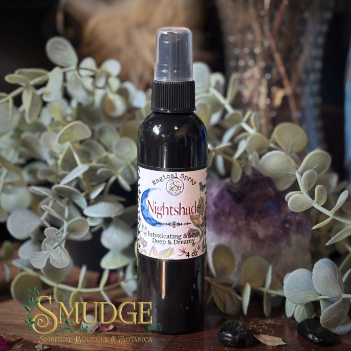 Bottle of 'Nightshade' spray with a label on a wooden surface surrounded by plants and crystals.