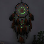 Decorative dreamcatcher with glowing beads on a wall.
