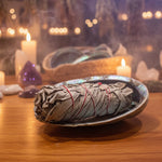 Rolled sage on a shell dish with a woven basket in the background