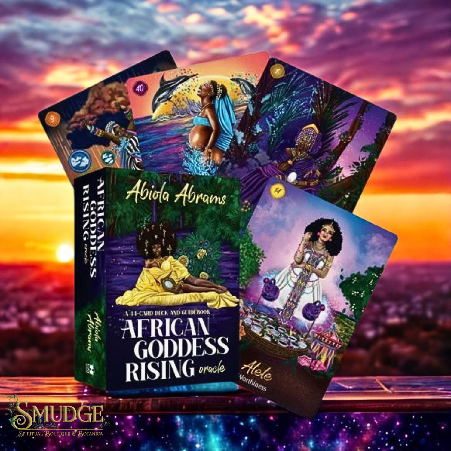 A boxed oracle card deck titled 'African Goddess Rising' by Abiola Abrams is shown with several illustrated cards fanned behind it. The artwork features a woman in a yellow dress, a figure in blue, and mystical scenes in purple, green, and gold tones.