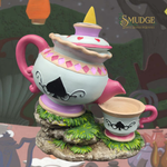 Decorative teapot and cup set with a cartoonish design on a whimsical background.