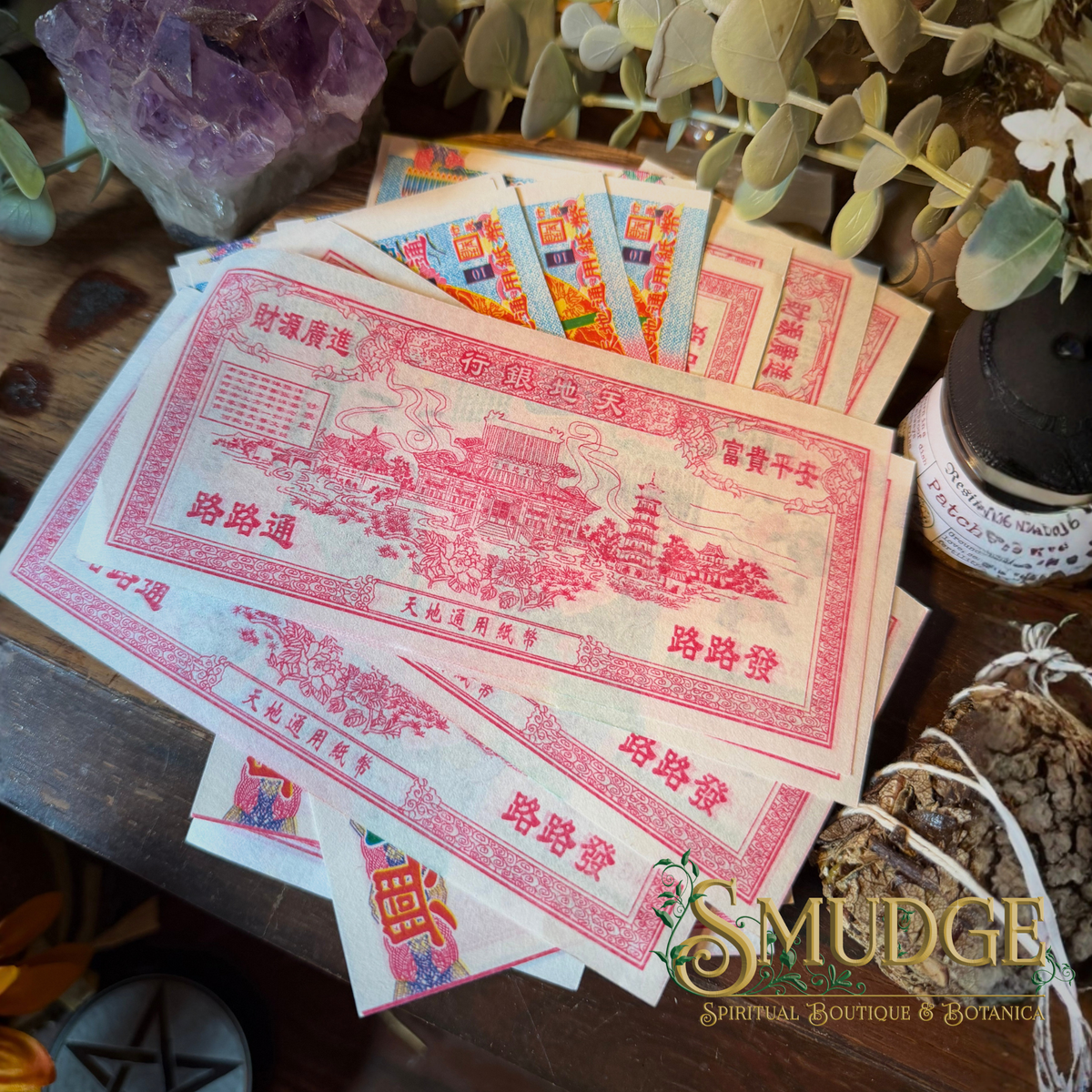 A fan of vintage-style Chinese railway ticket art prints or cards displayed on a wooden surface, surrounded by botanical props including eucalyptus leaves, a purple crystal cluster, dried roots, and a small jar. The cards feature pink/red illustrated linework and text on off-white paper.