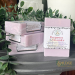 Bergamot & Lavender soap bars with packaging on a surface with greenery in the background