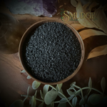 Wooden bowl with black salt in a bowl, on a wooden surface with 'Smudge' branding.