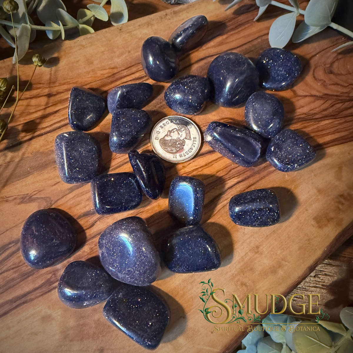Blue goldstone tumbled stones on a wooden background
