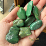 Hand holding green stones with Smudge logo