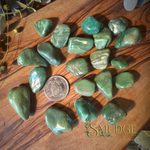 Buddstone green tumbled stones on a wooden background.