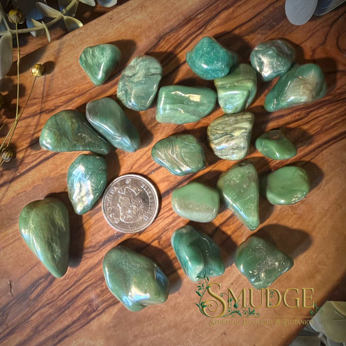 Buddstone green tumbled stones on a wooden background.