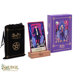 Buffy the Vampire Slayer tarot deck set including a purple box, a Justice tarot card on a wooden base, and a black drawstring bag with gold lettering, shown on a white background with a Smudge logo.
