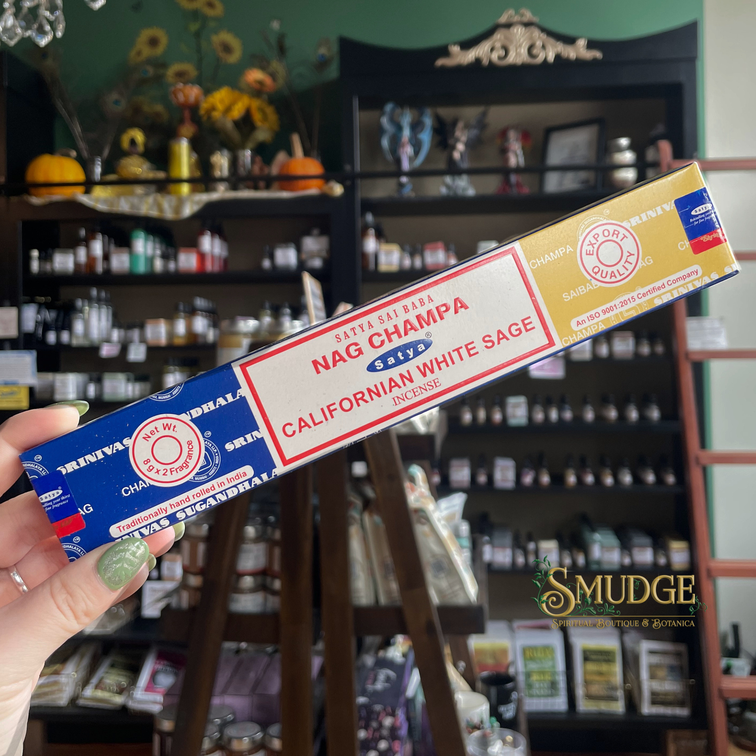 Nag Champa Californian White Sage incense box held in front of a store shelf.