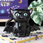 Cat Bat shaped ceramic mug on a notebook, purple background and Smudge logo top left corner