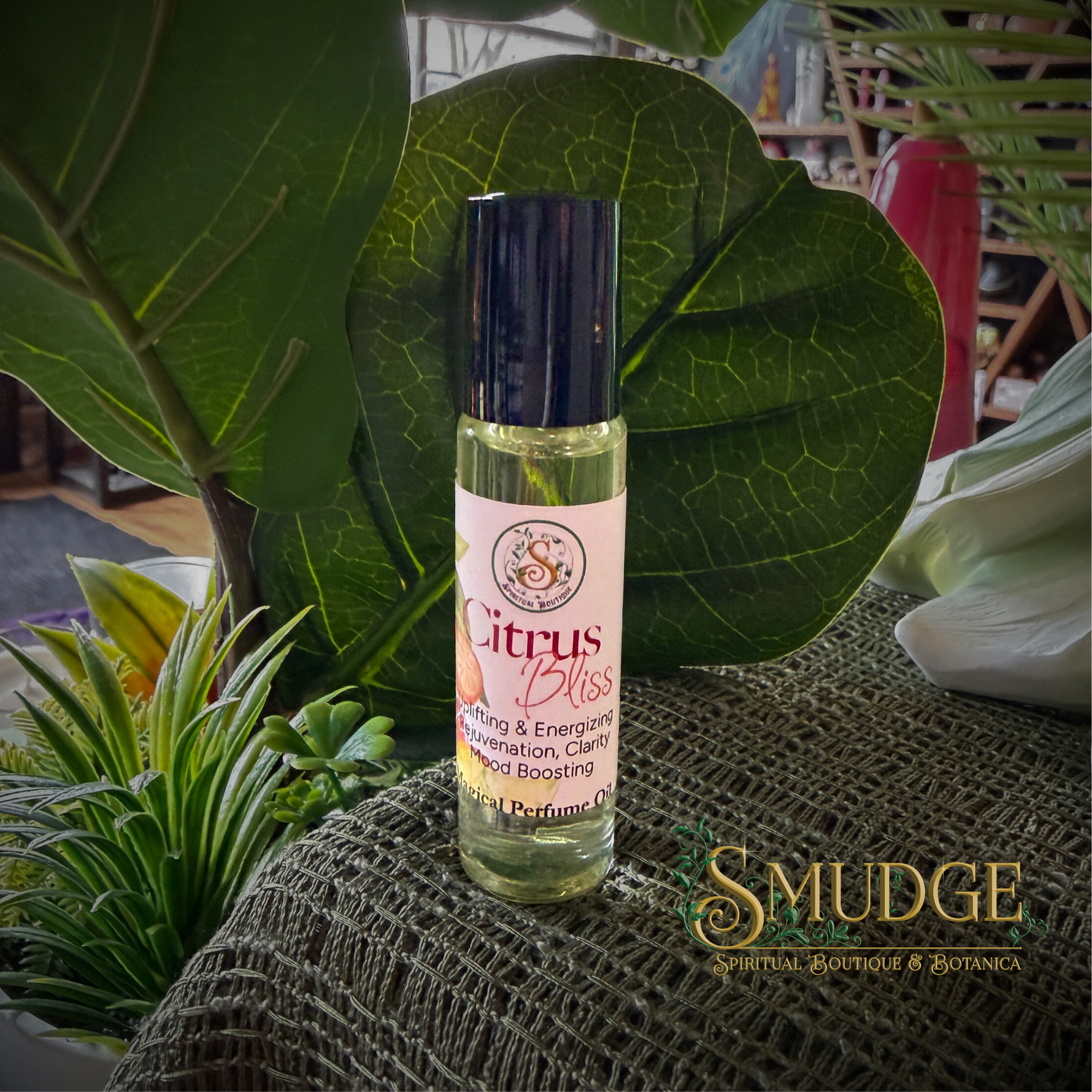 Roll-on bottle of 'Citrus Bliss' perfume with green leaves and plants in the background, featuring the brand 'Smudge'.